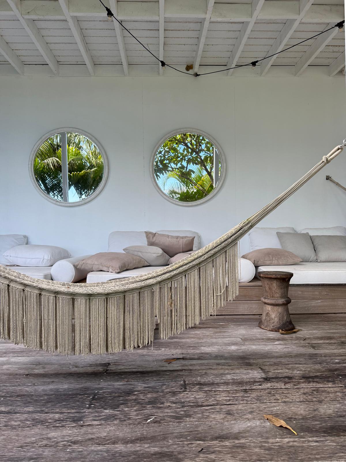 Tropical lounge with macrame hammock and porthole windows