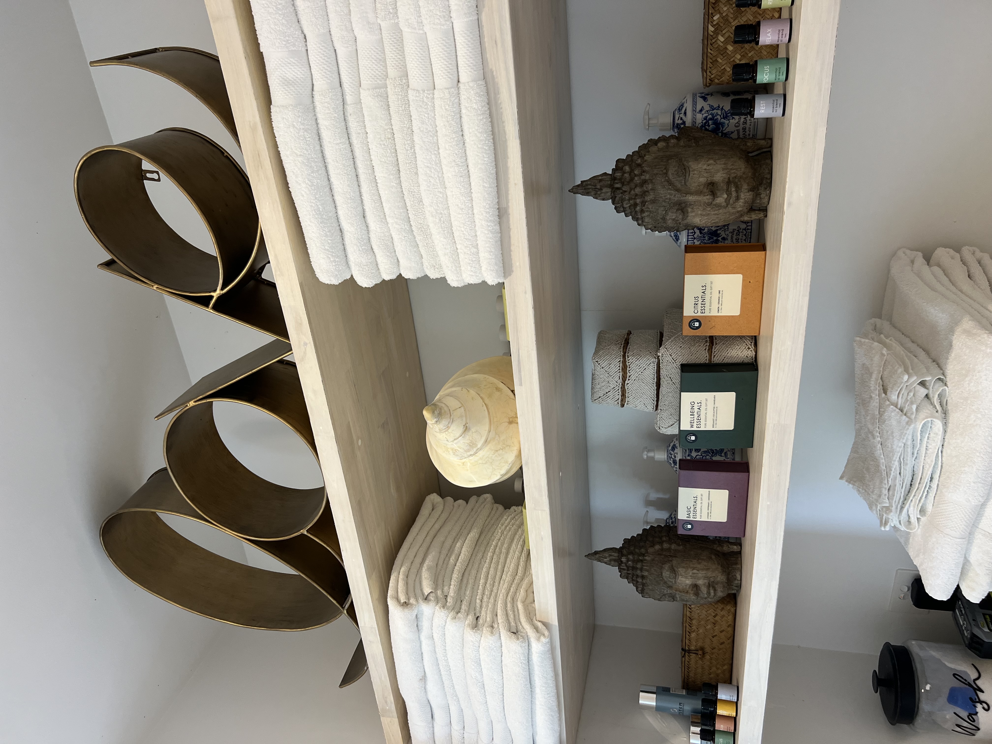 Spa shelving with towels and Buddha decor