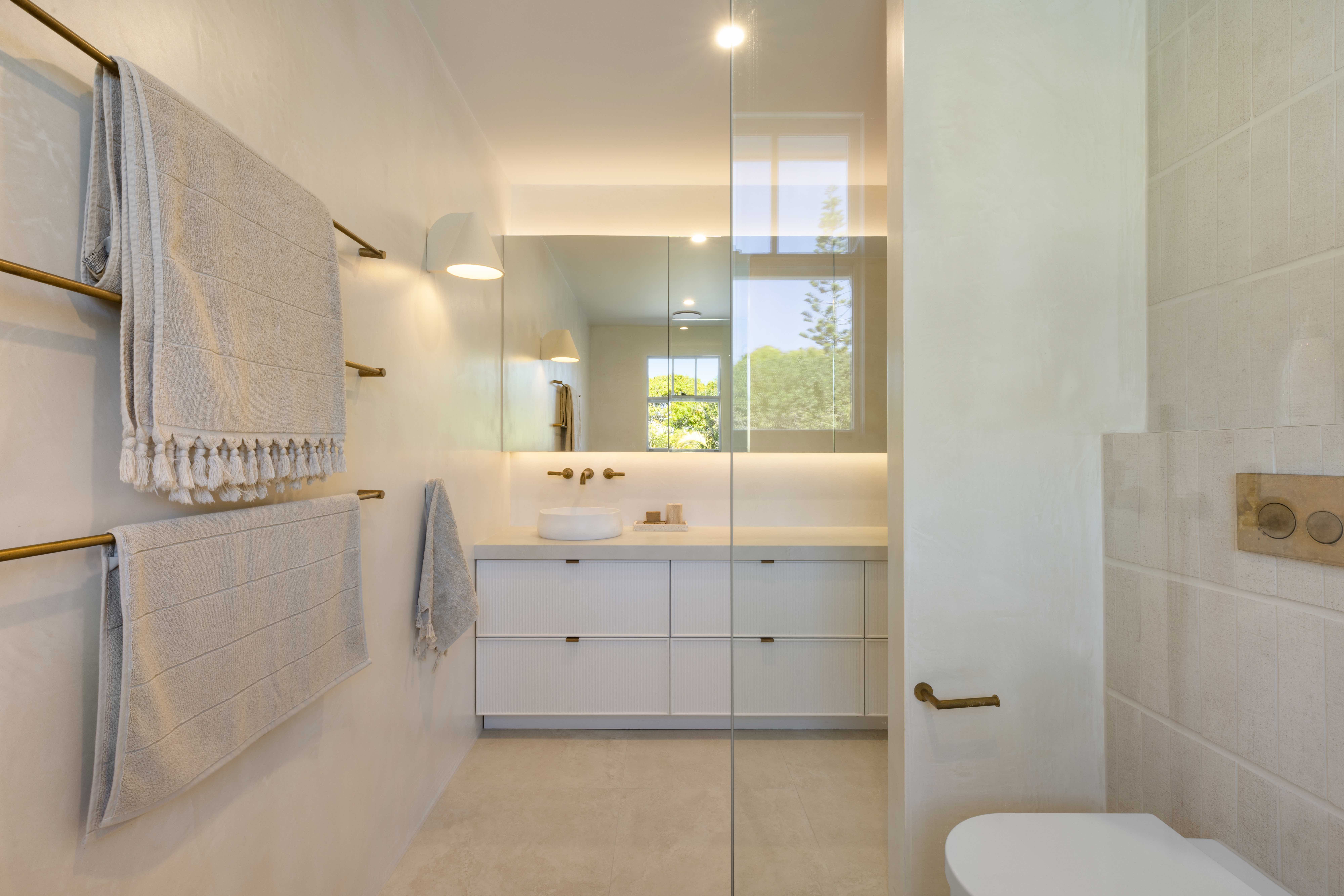 Modern bathroom with brass fixtures and floating vanity