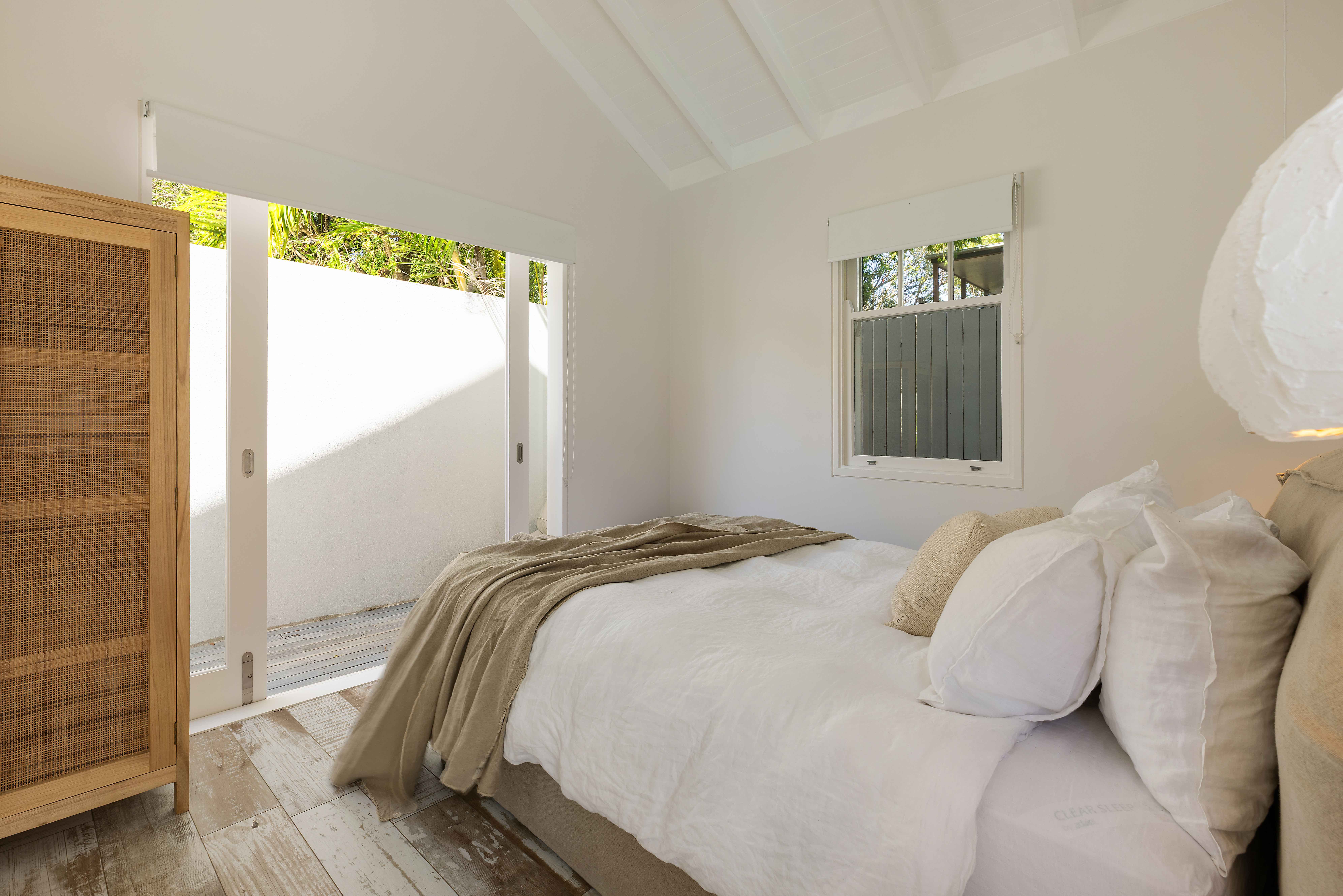 Minimalist bedroom with vaulted ceiling and ocean views