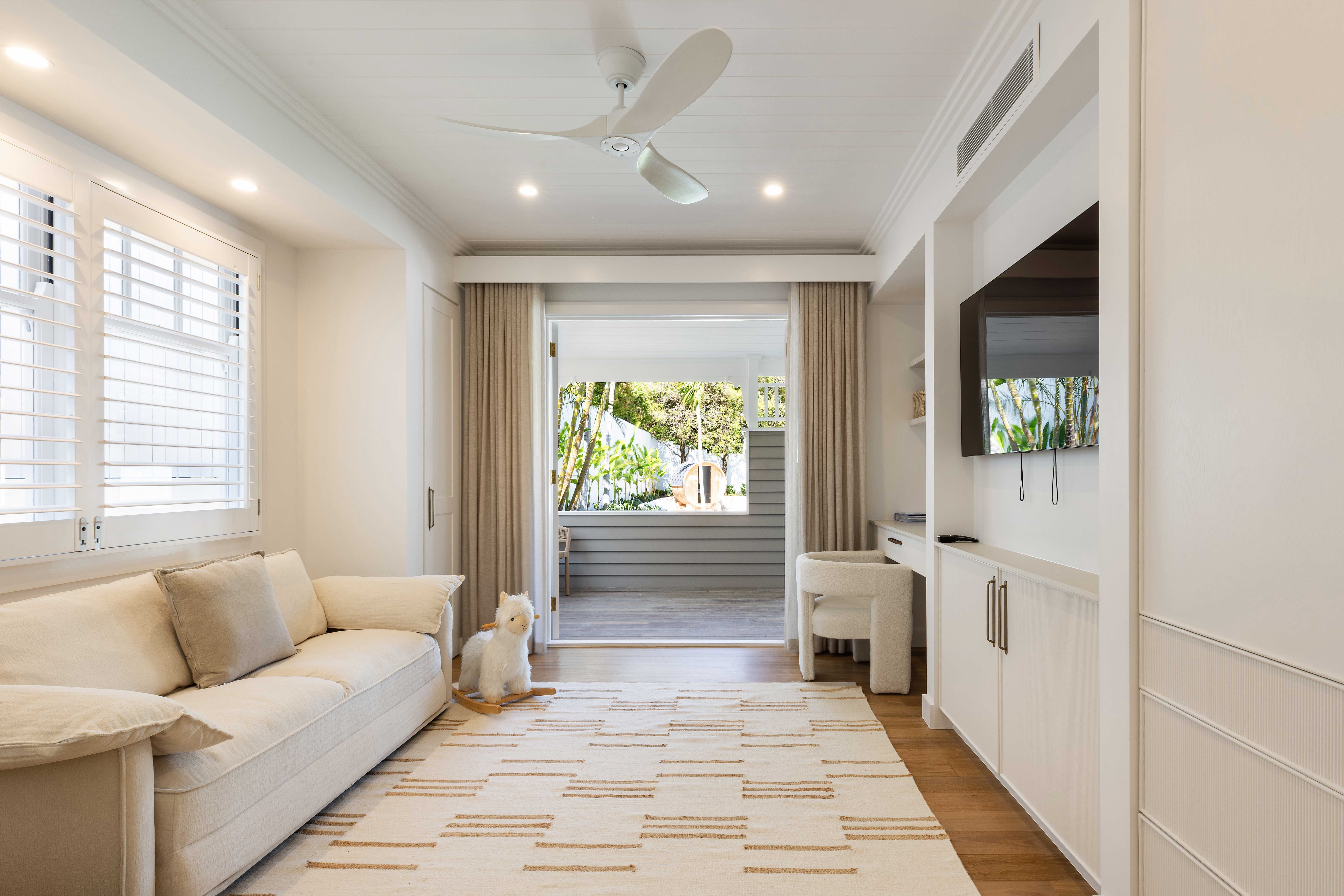 Guest room with entertainment unit and plantation shutters