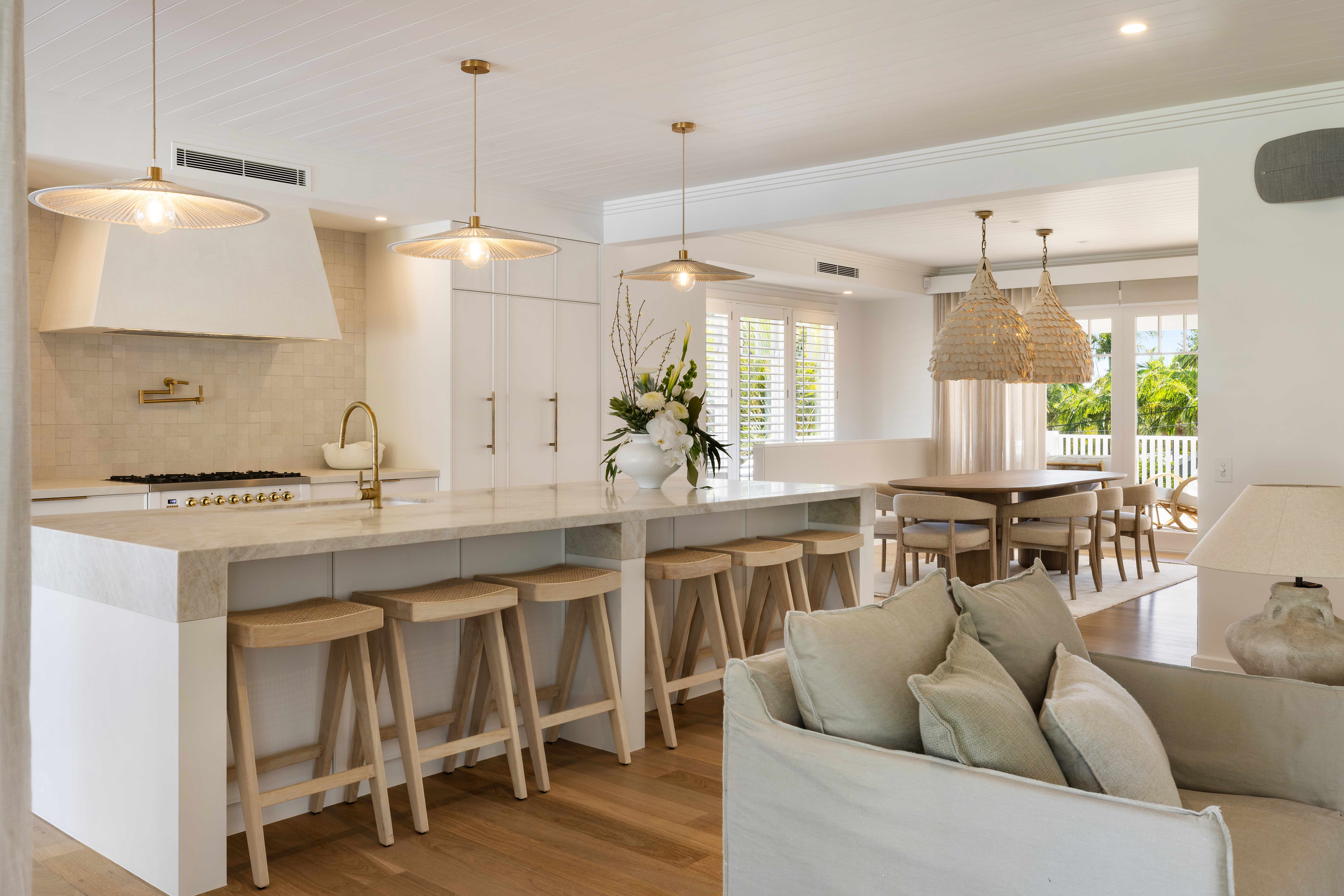 Kitchen island with woven bar stools and pendant lights