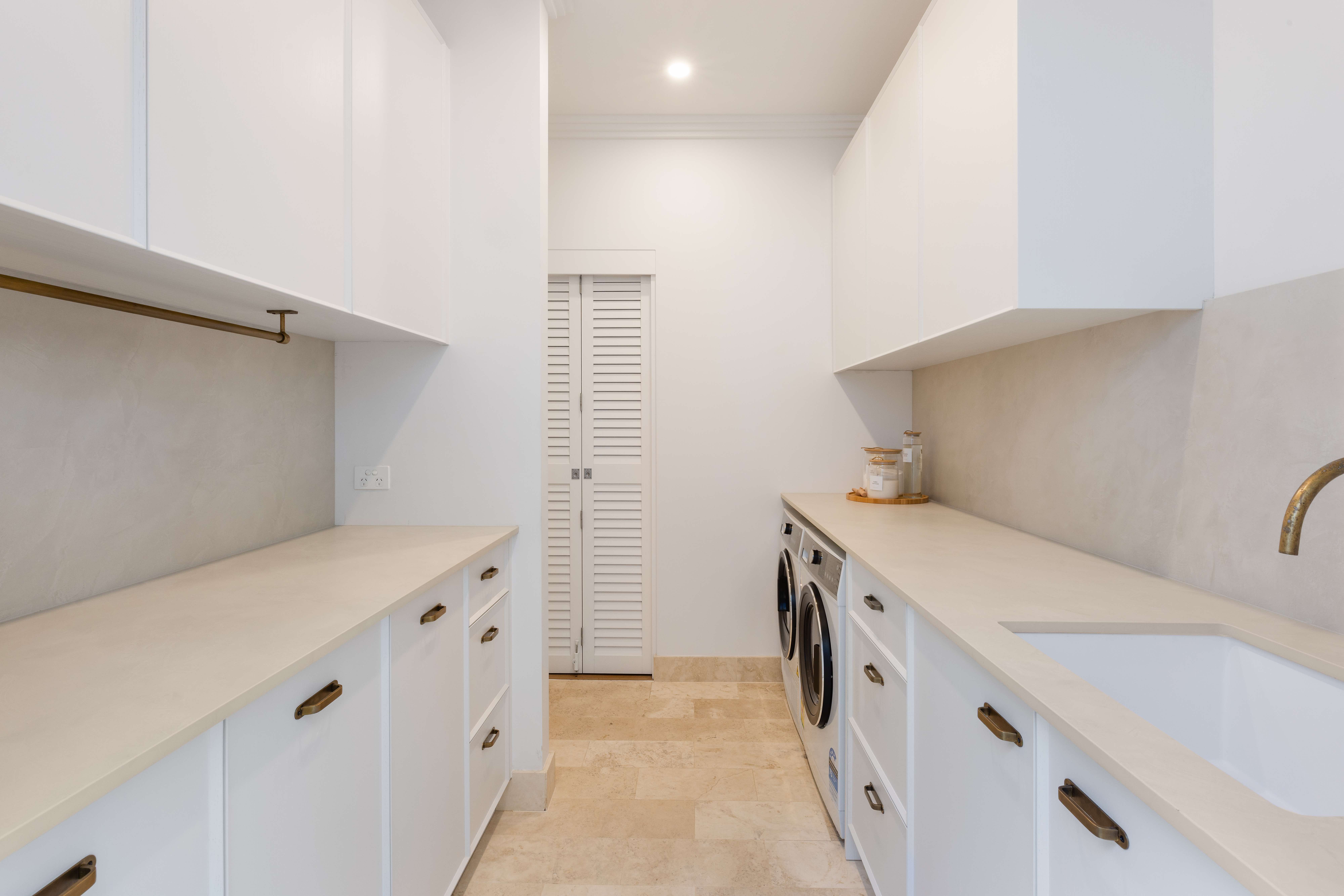 White laundry room with brass hardware