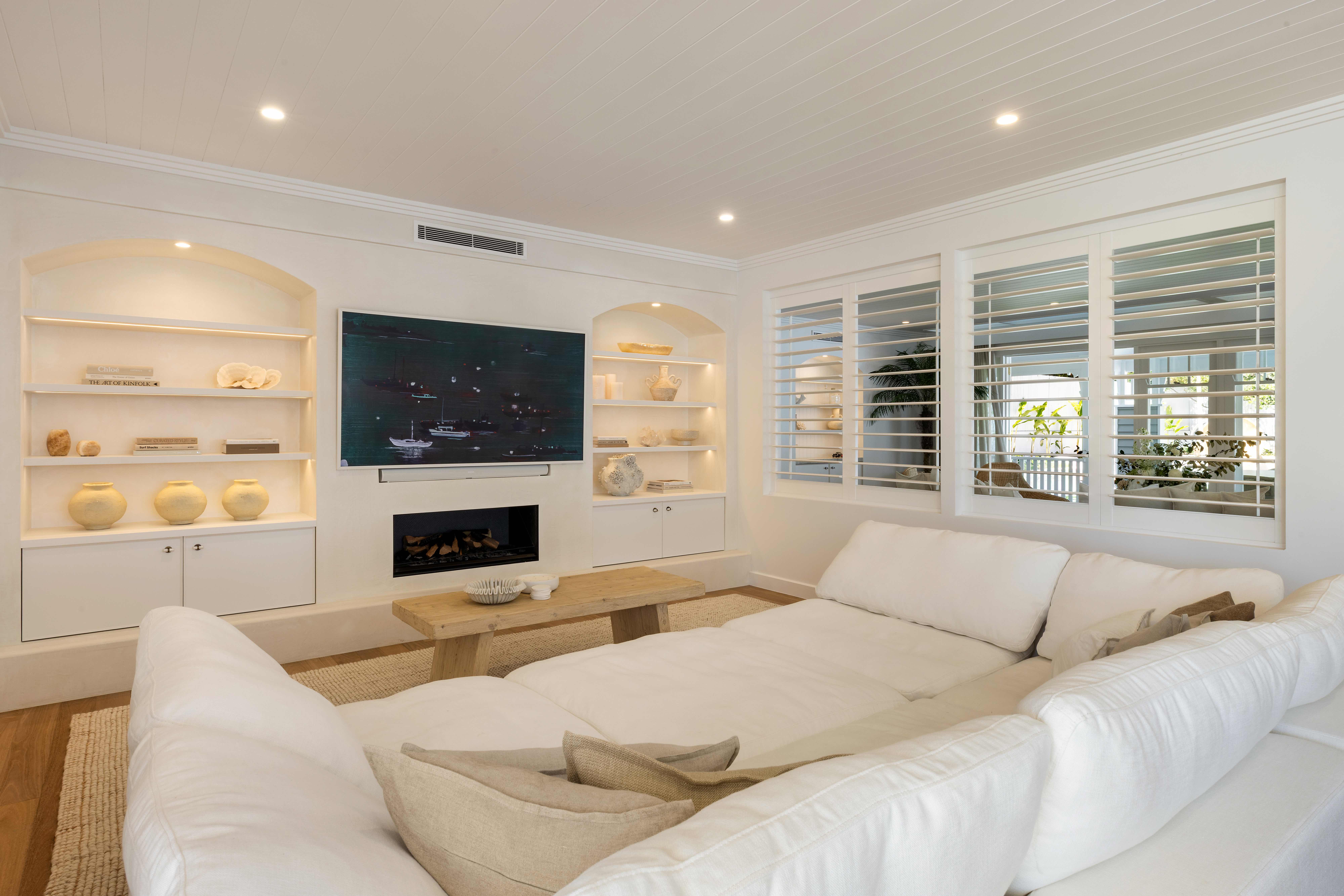 White living room with built-in shelving and fireplace
