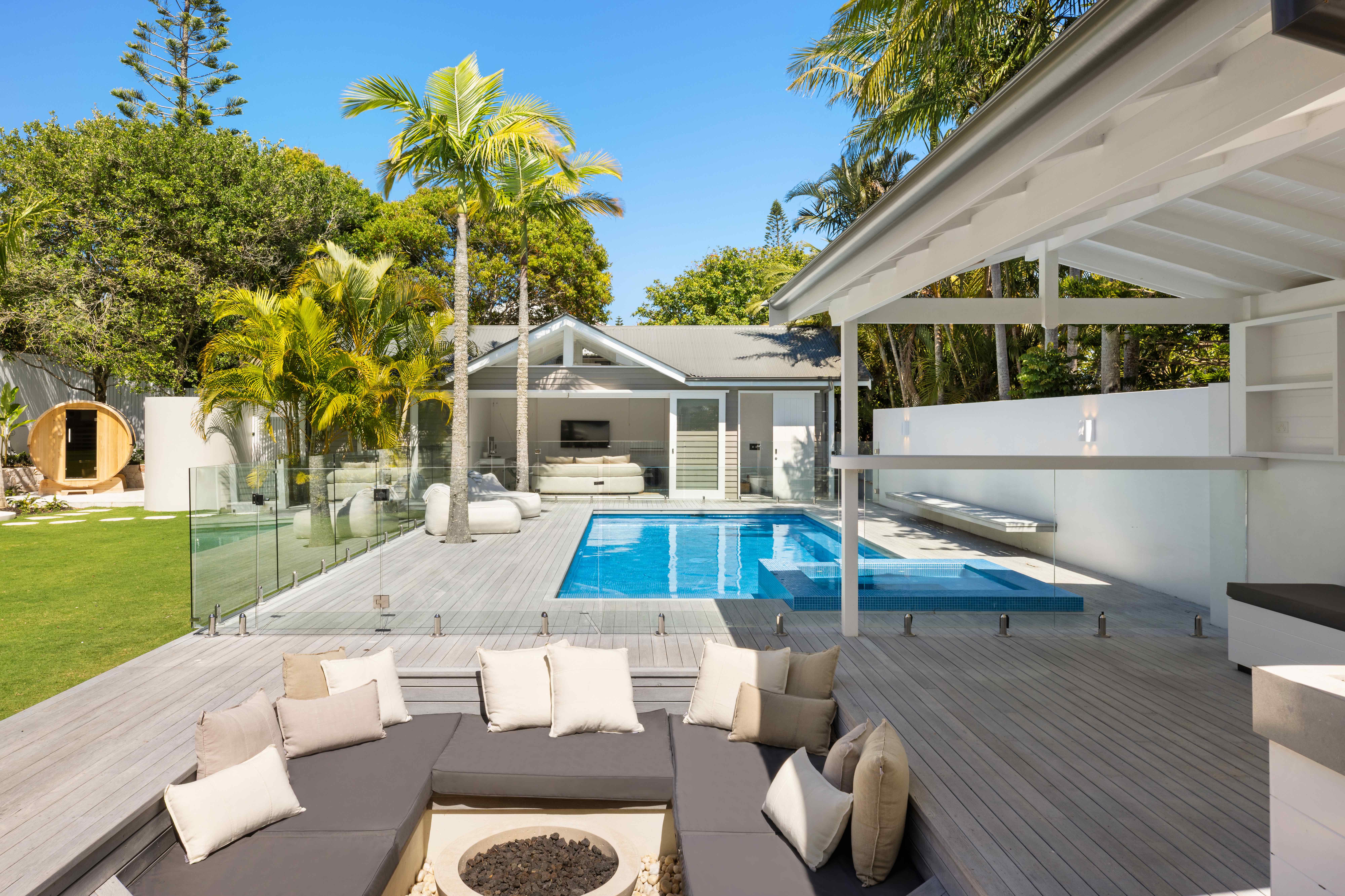 Outdoor lounge with fire pit, pool and barrel sauna