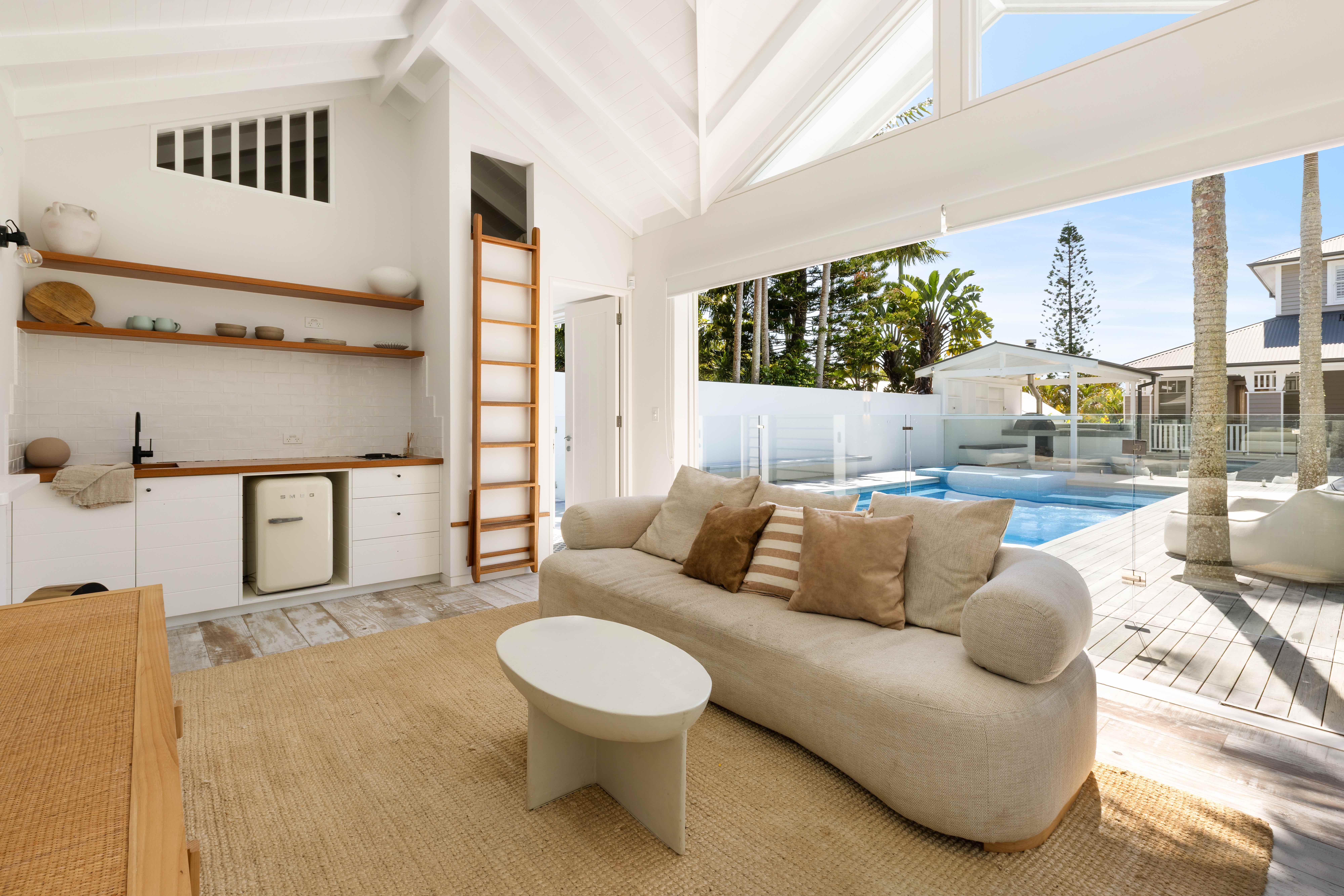 Pool house interior with curved sofa and ocean views