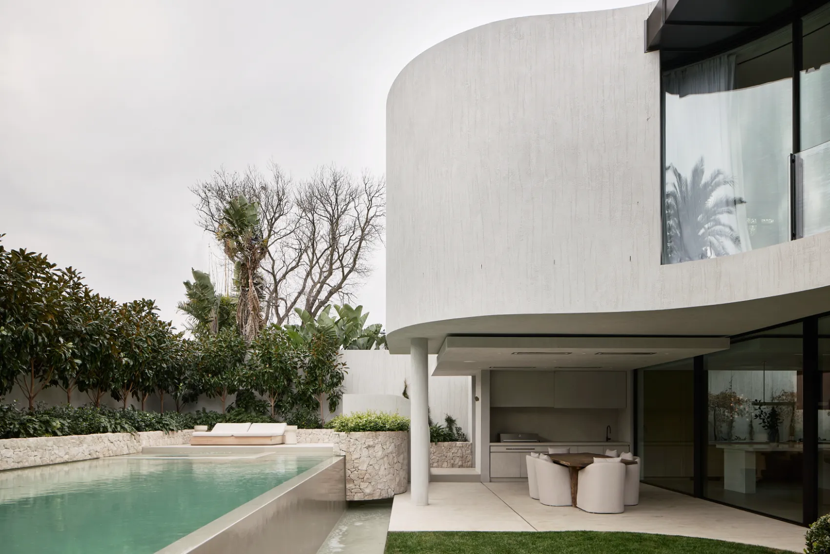 Pool area with curved architecture and outdoor dining