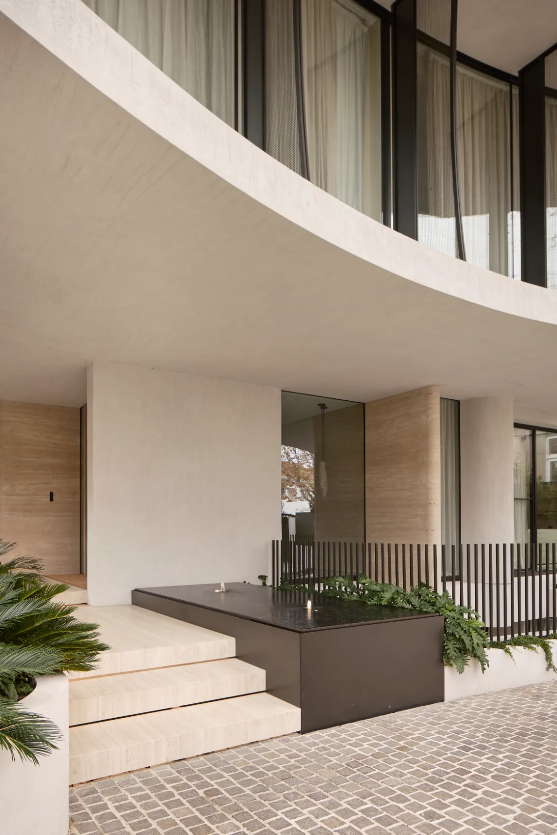 Entrance with travertine steps and water feature