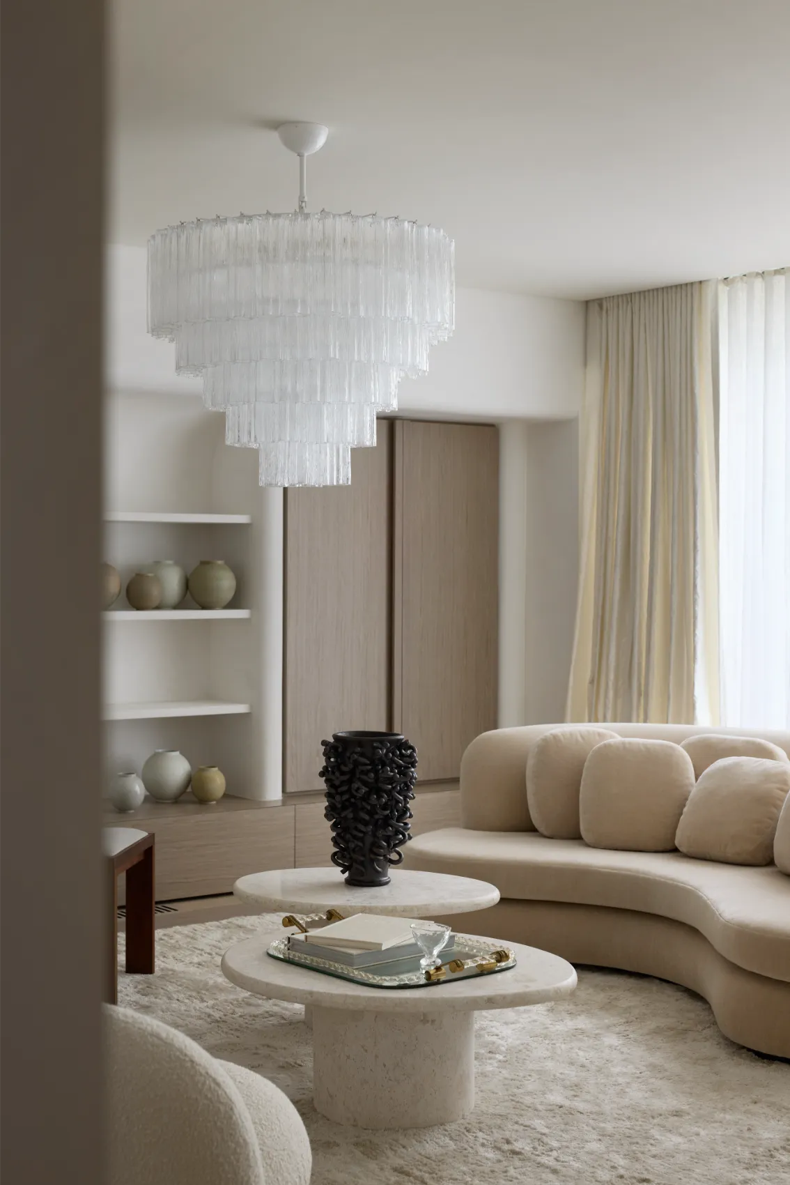 Living room with crystal chandelier and curved sofa