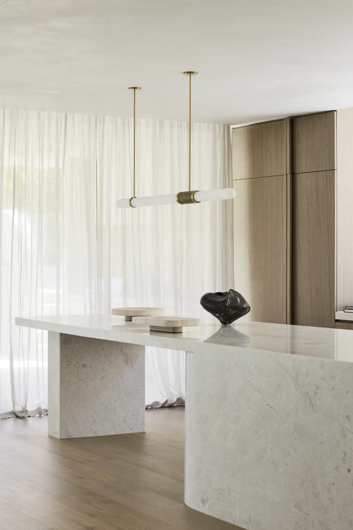 Marble kitchen island with brass pendant light