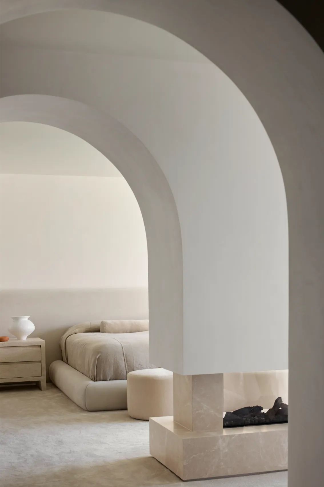 Bedroom with arched architecture and fireplace